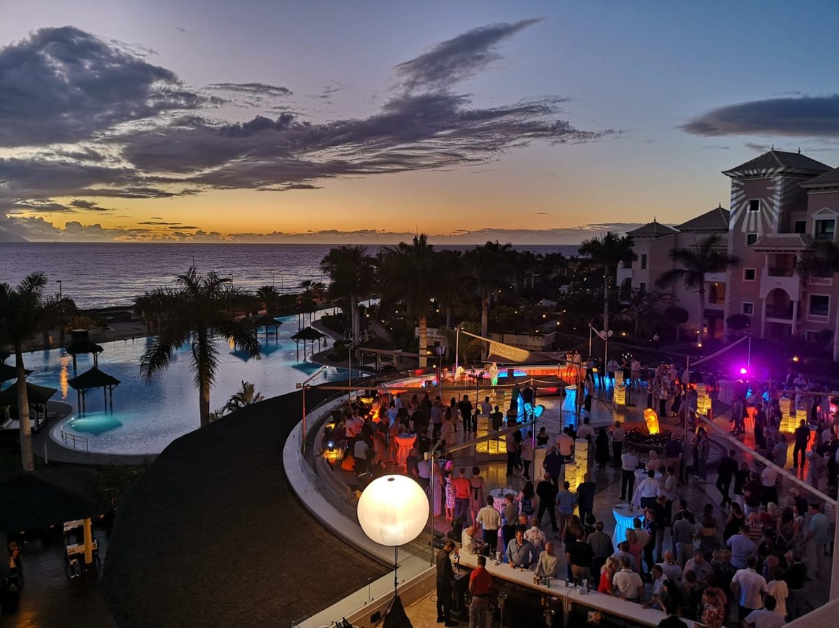 Fiesta de boda nocturna en una terraza frente al mar al atardecer